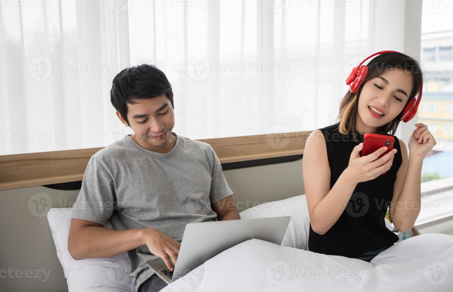 le couple a mis ses écouteurs et écouté de la musique sur son téléphone portable sur le canapé et ils dansaient heureux dans la maison pour la distance sociale et le concept de responsabilité personnelle photo