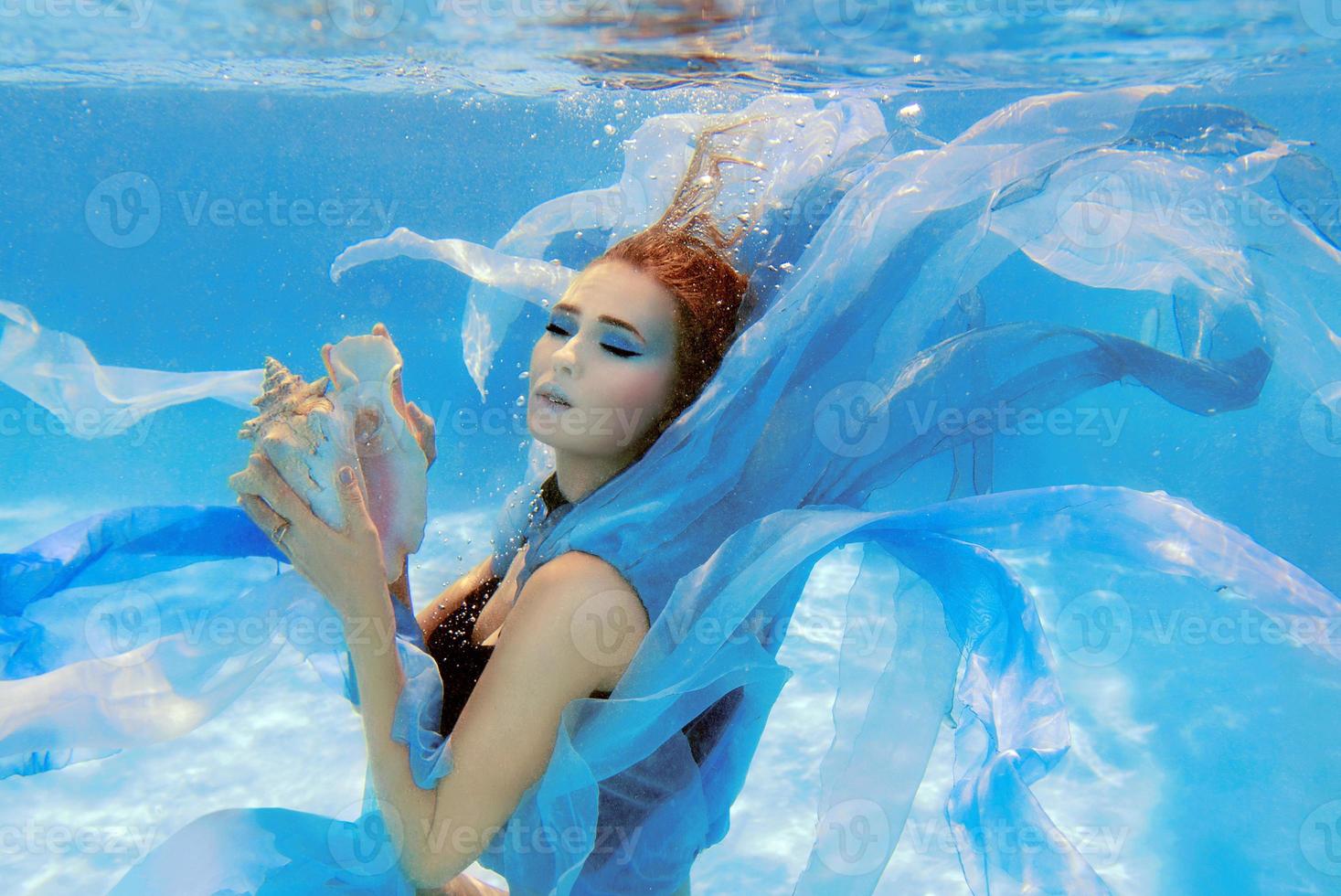 portrait de mode sous-marine d'une belle jeune femme en robe bleue photo