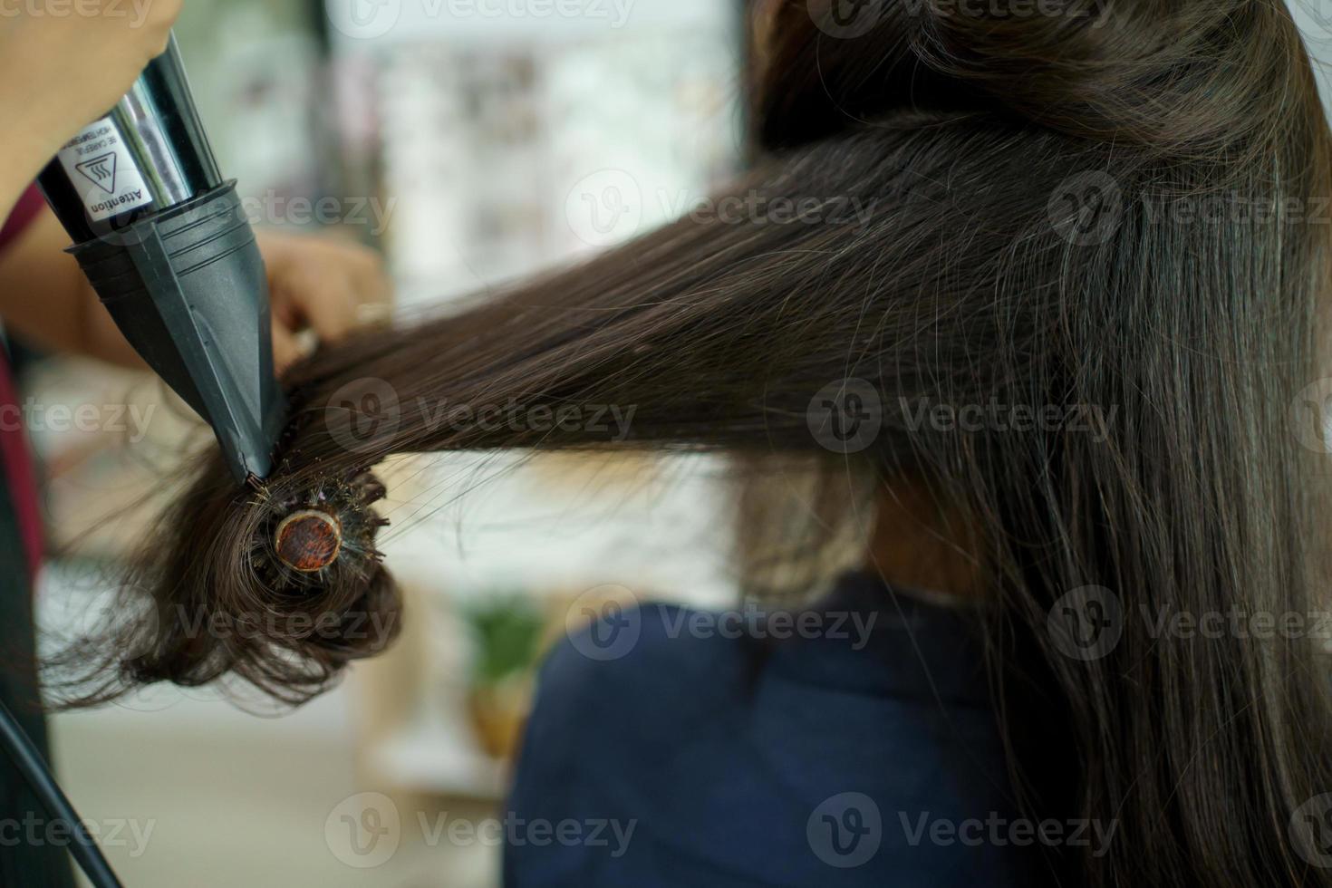 coiffeur professionnel faisant une coloration et un traitement des cheveux dans un magasin de beauté et de salon. femme changeant de couleur de cheveux dans un magasin de salon professionnel. photo