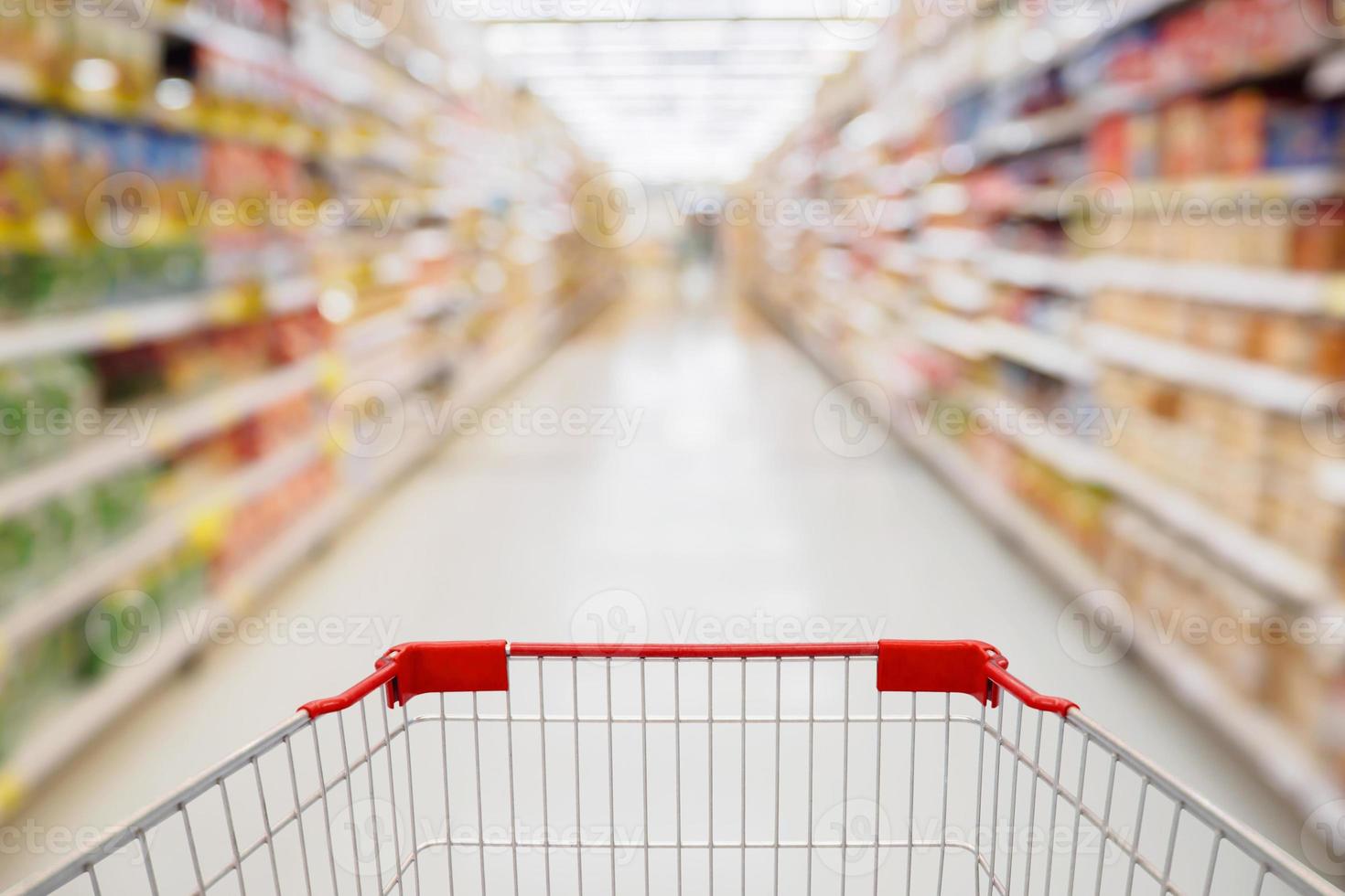 panier vue dans l'allée du supermarché avec des étagères de produits flou abstrait arrière-plan défocalisé photo