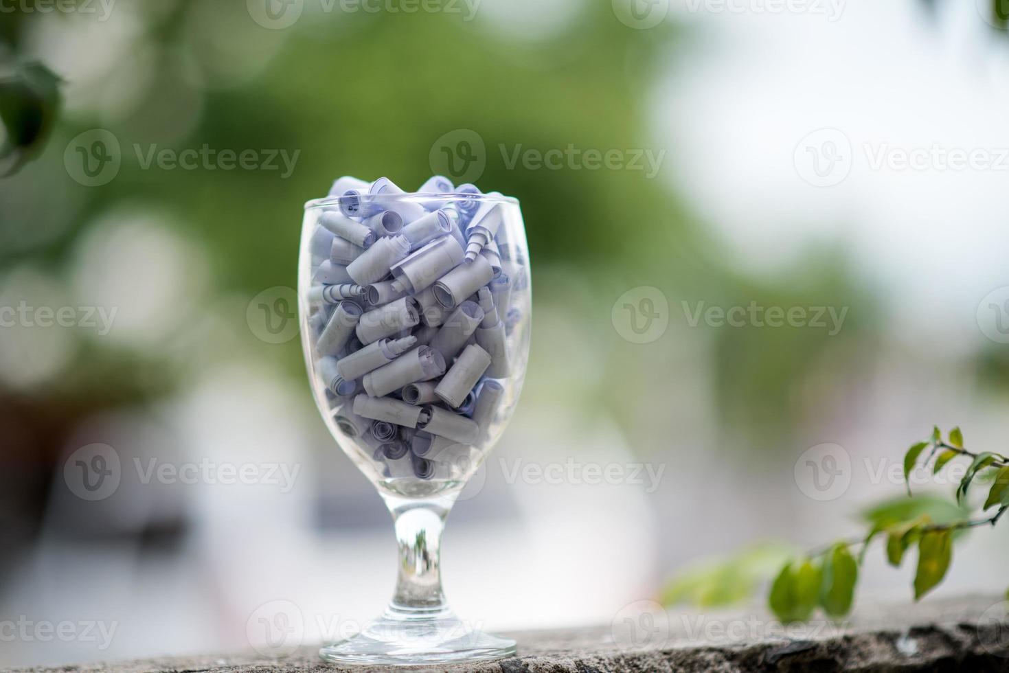 un verre de vin clair avec du papier blanc à l'intérieur du concept de remplir les bonnes choses dans un verre de clair. photo