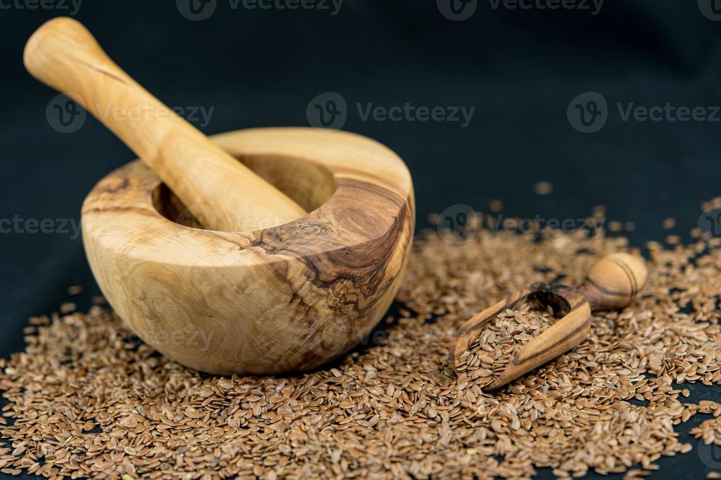 un tas de graines de lin et des ustensiles en bois d'olivier photo