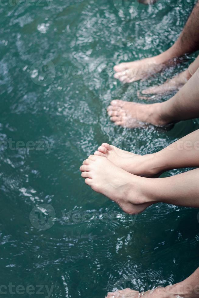 voyage d'été en famille, détente avec les jambes dans l'eau. photo