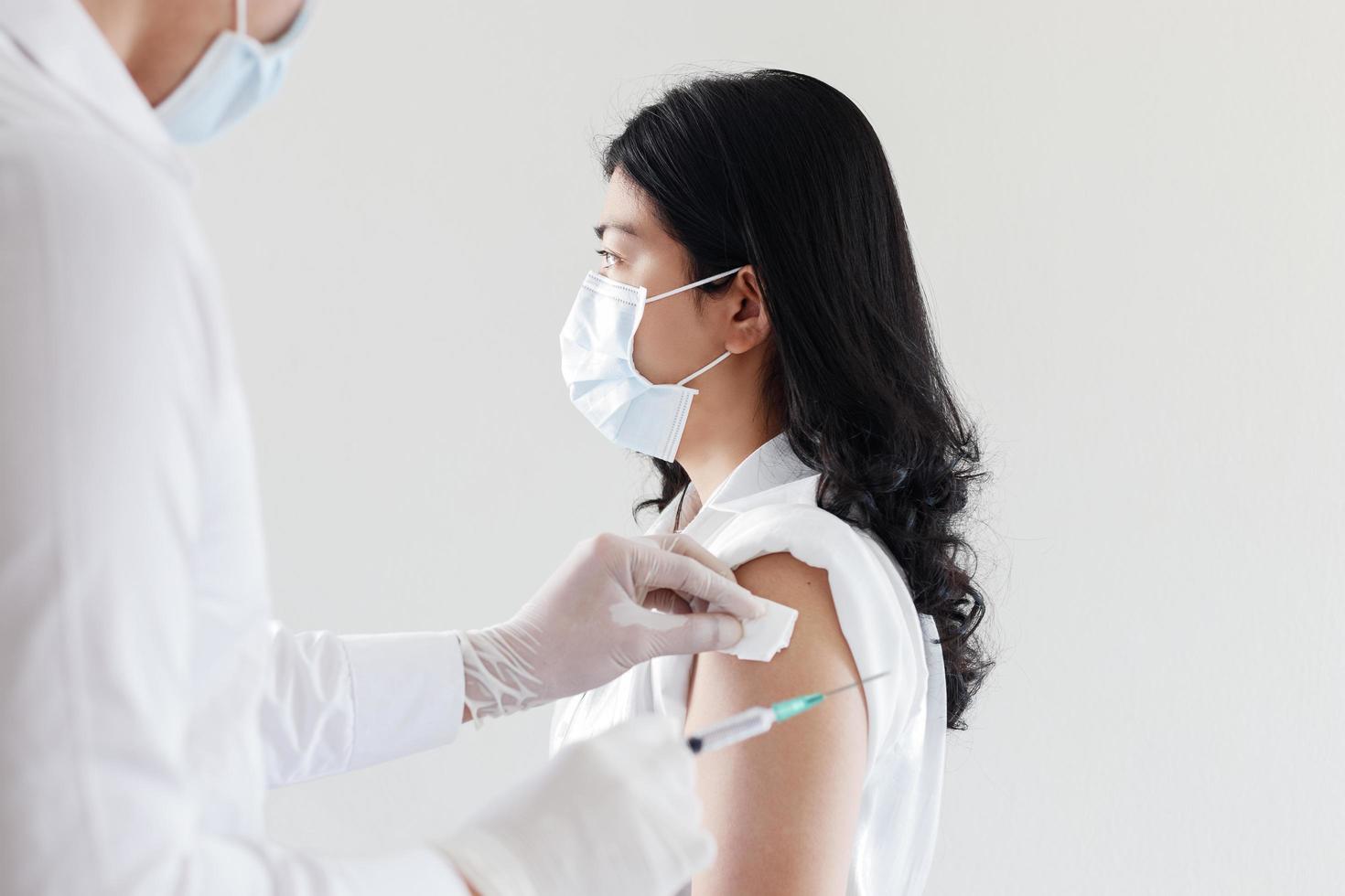 médecin donnant le vaccin covid aux femmes asiatiques photo