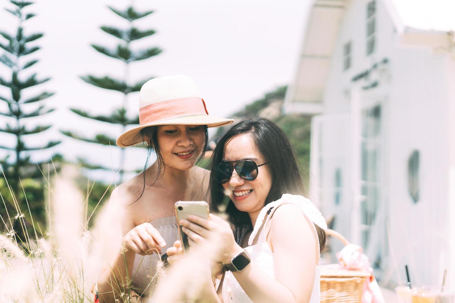 amitié de jeunes femmes asiatiques adultes utilisant un téléphone portable pour les médias sociaux. photo