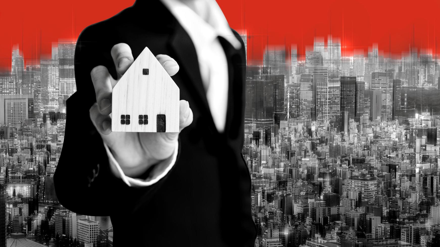 homme d'affaires agent immobilier tenant le modèle de maison pour l'investissement sur fond de ville en couleur de thème noir et blanc. photo