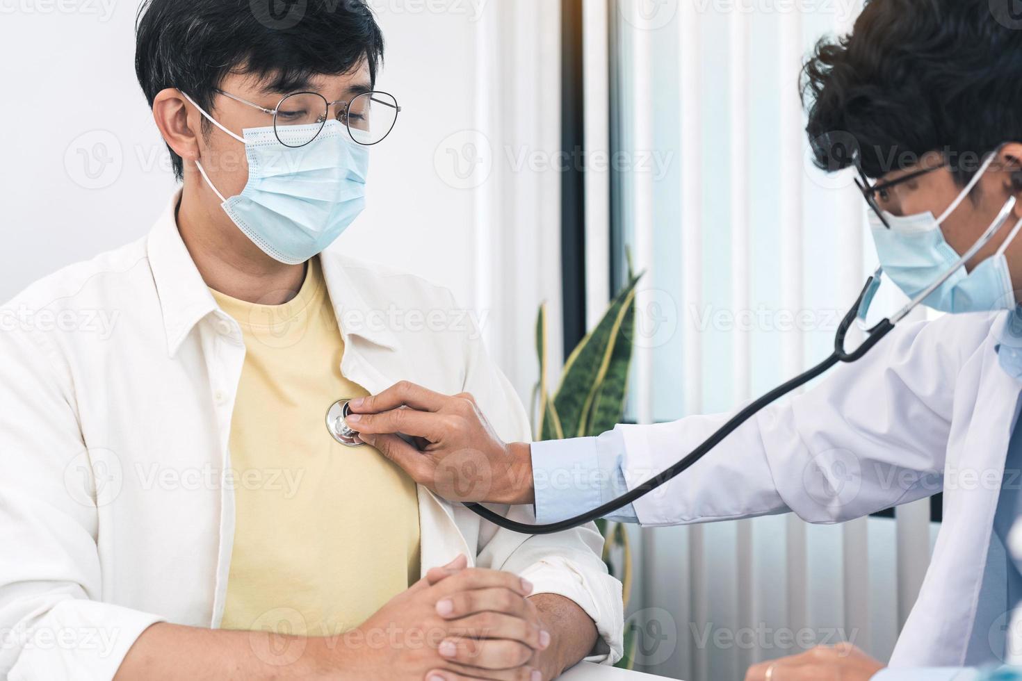 un médecin asiatique utilise un stéthoscope pour écouter le rythme cardiaque du patient. photo