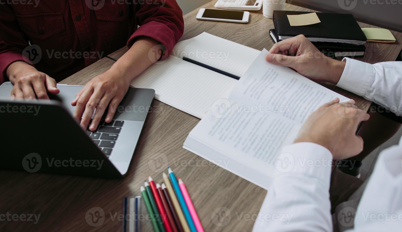 des amis étudiants utilisent un ordinateur portable pour rechercher des informations sur la lecture en classe. photo