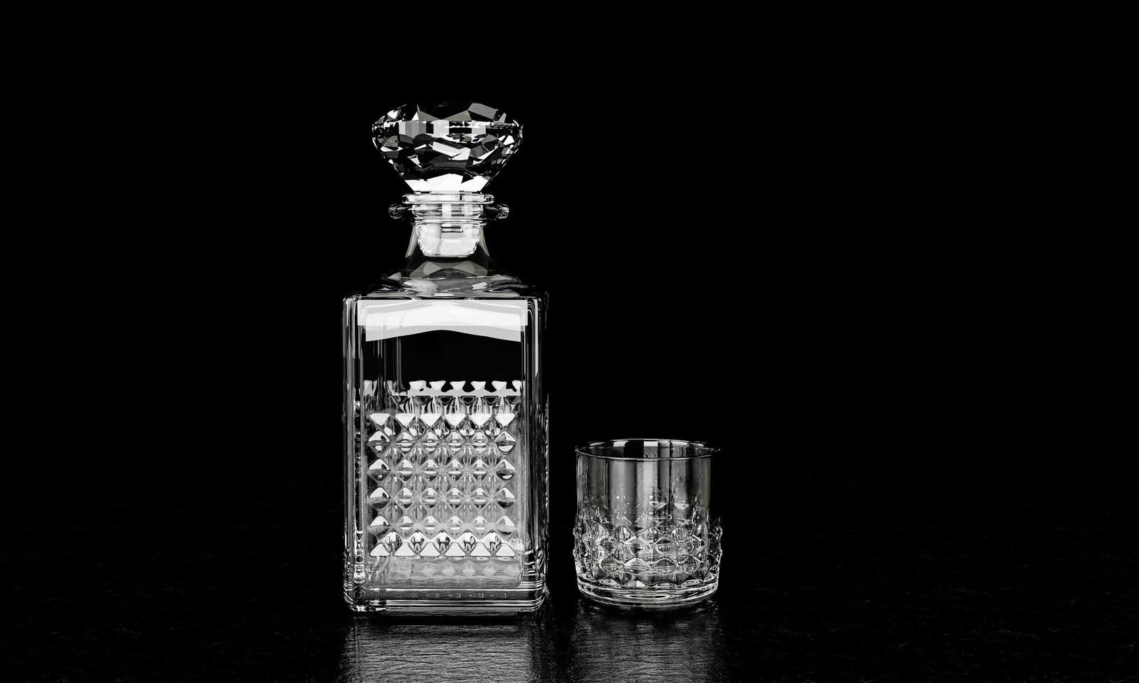 la bouteille et le verre ont un motif élégant pour le brandy ou le whisky. la bouteille en verre a un bouchon en forme de losange. le flacon et le verre sont en cristal avec un fond noir et un fond noir photo