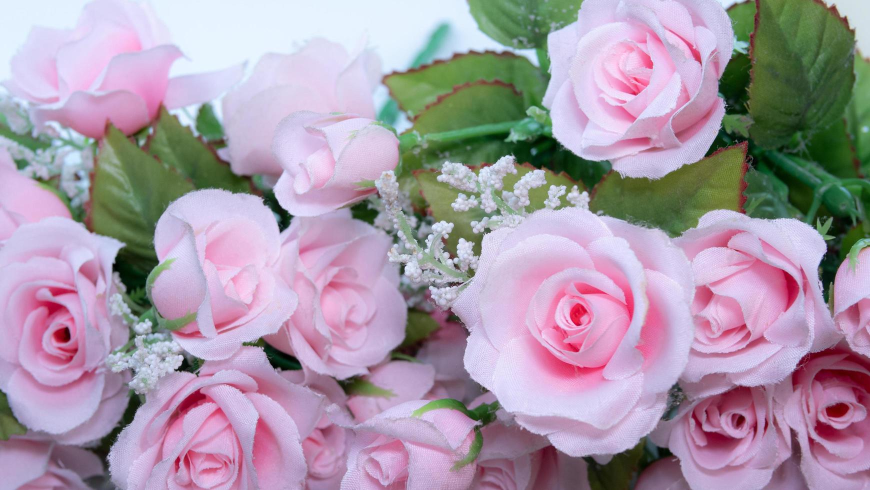 bouquet de roses roses posé sur une surface blanche pour créer des cadres et un arrière-plan dans le concept de la saint-valentin. un faux bouquet en tissu et plastique. photo