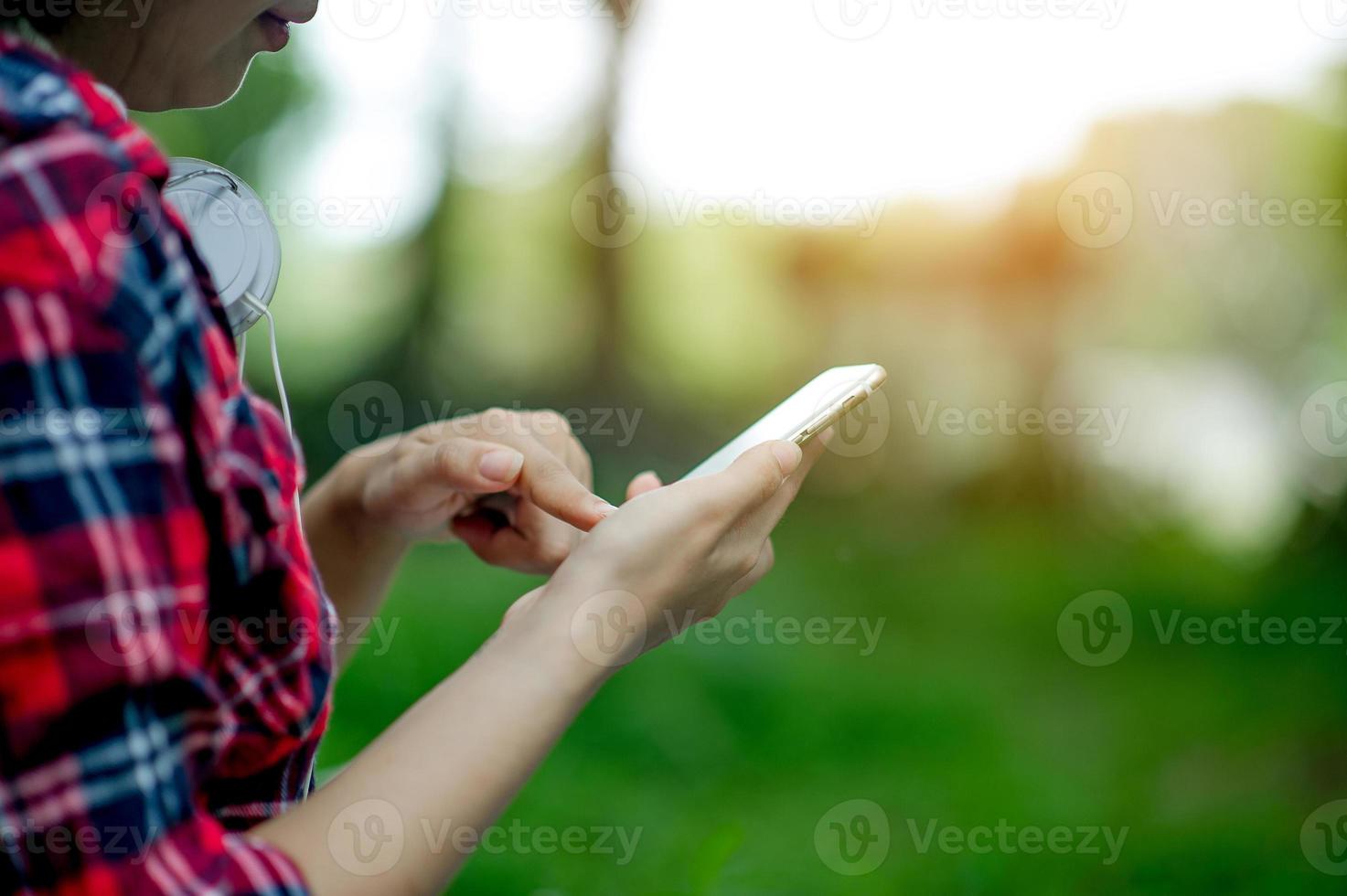 fille jouant au téléphone à portée de main pour la communication en ligne et le contact porte une chemise rouge et un fond vert et il y a un espace de copie. photo