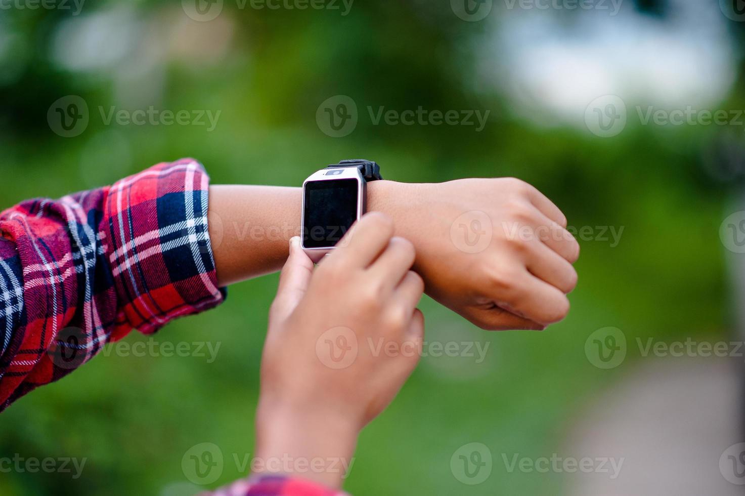 les mains et les montres numériques des garçons regardent l'heure au poignet. l'orientation est ponctuelle. photo