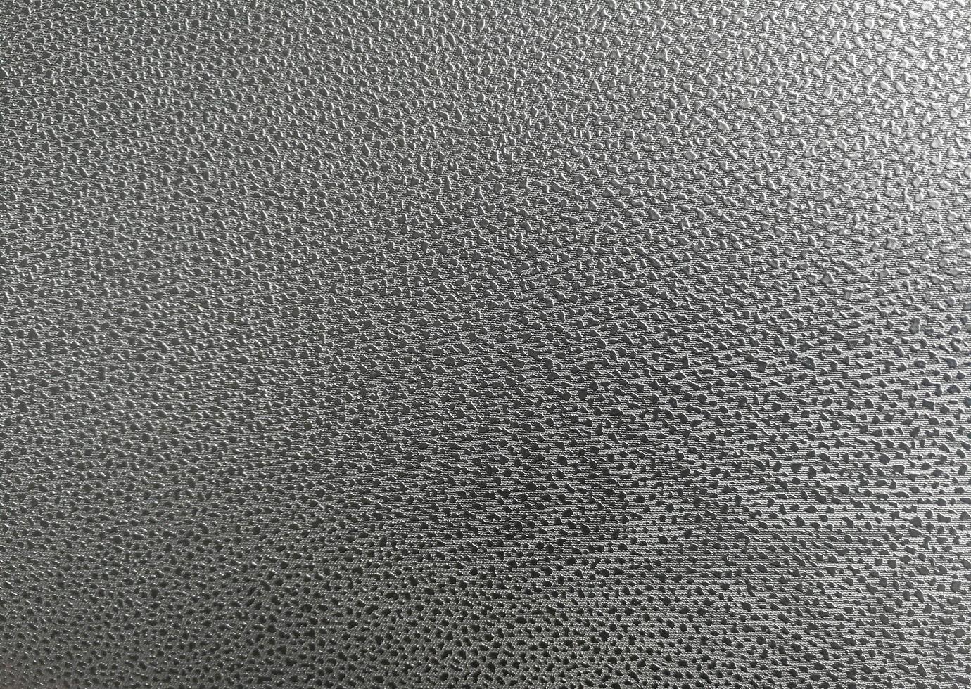 motif à pois sur la surface en cuir artificiel. il y a de la lumière qui brille du coin supérieur. photo