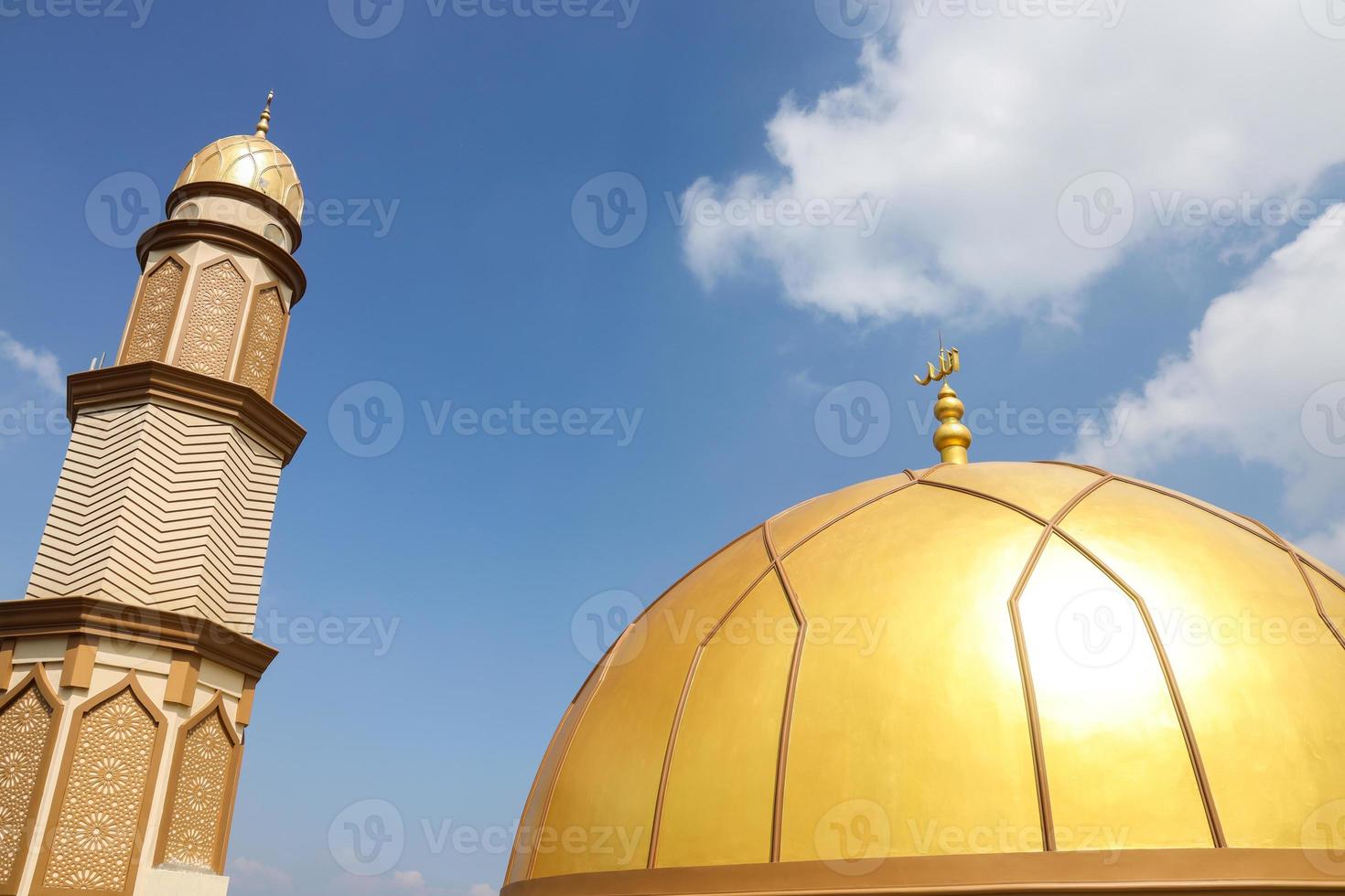 dôme doré et haute tour de la mosquée avec fond de ciel photo