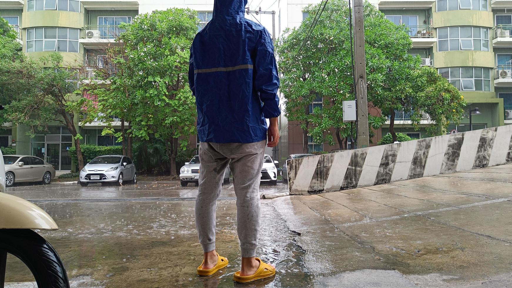 homme debout avec son dos portant un imperméable photo