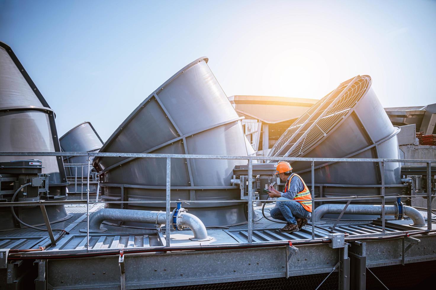 ingénieur de l'industrie en cours de vérification du climatiseur de la tour de refroidissement de l'industrie est le refroidisseur d'air de la tour de refroidissement par eau cvc d'un grand bâtiment industriel pour contrôler le système d'air. photo