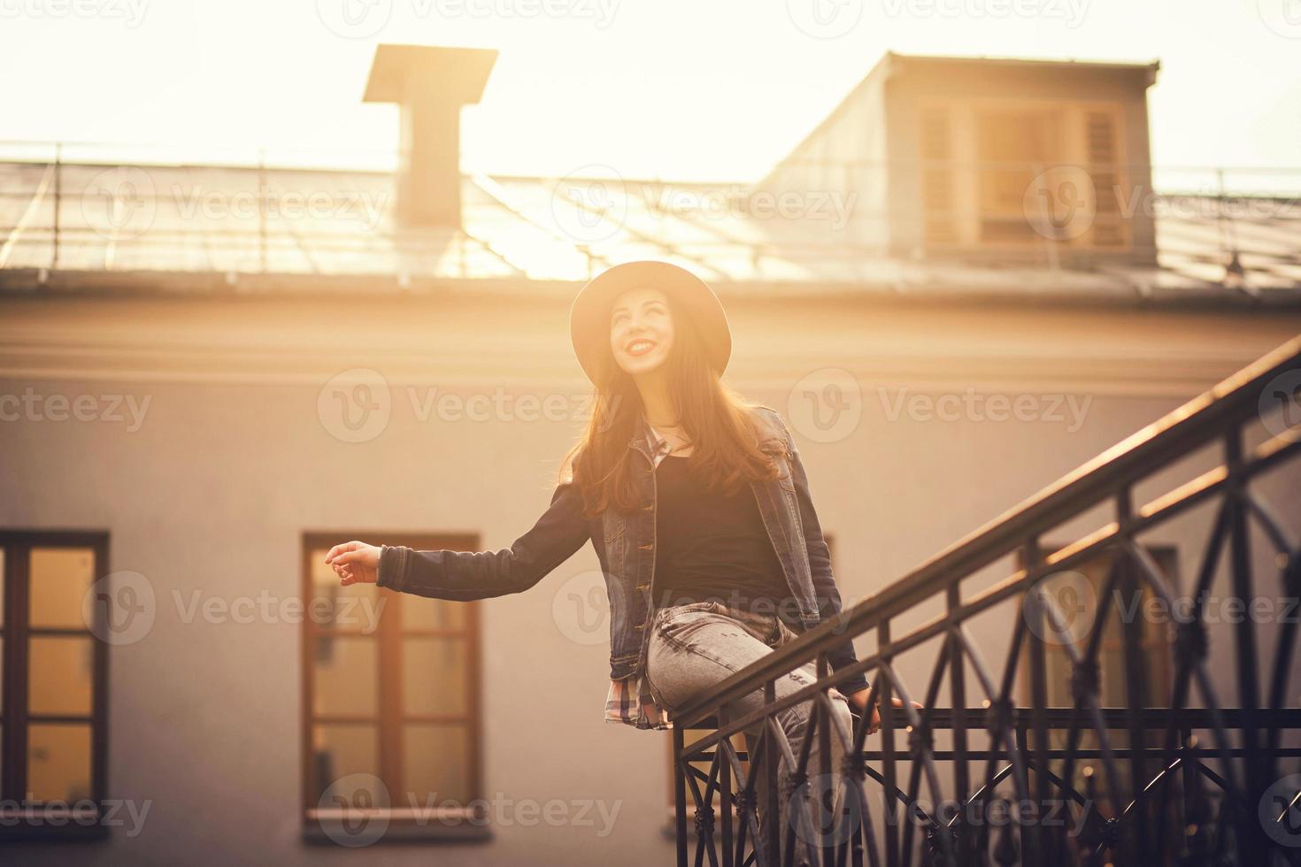 portrait d'une fille heureuse assise sur la balustrade photo