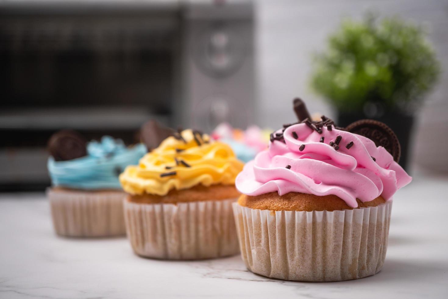délicieux cupcakes faits maison avec crème colorée et garniture de bonbons et biscuits au chocolat. dessert de vacances d'automne fait maison photo