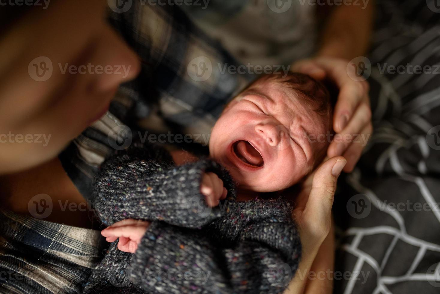 maman tient dans ses bras son fils nouveau-né. photo