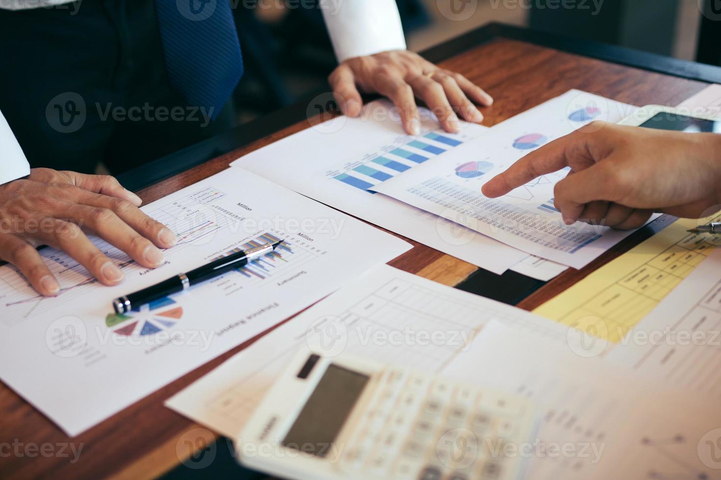 les gens d'affaires pointant sur le résultat du numéro de statistique et le coût financier de l'analyse avec la vérification du graphique des rapports de synthèse au bureau. photo