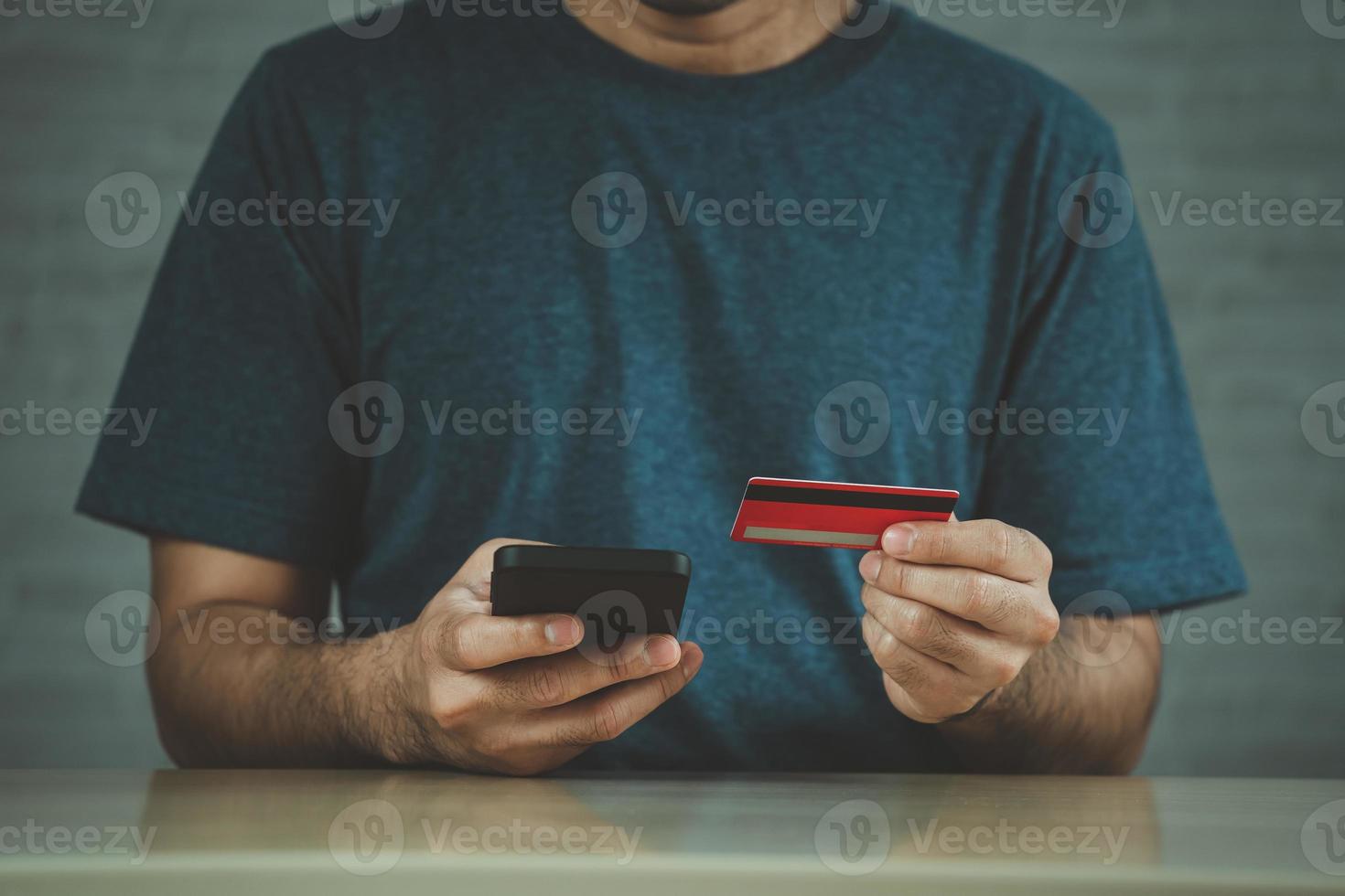 homme tenant une carte de crédit et utilisant un ordinateur portable. homme d'affaires travaillant à la maison. achats en ligne, commerce électronique, services bancaires par Internet, dépenser de l'argent, travail à domicile. photo