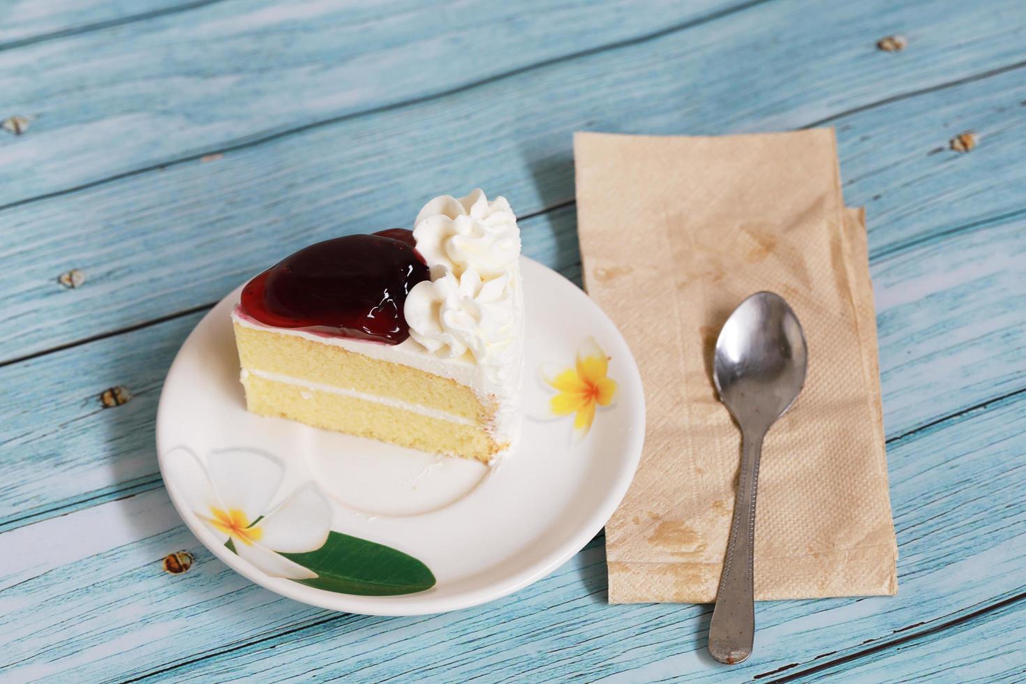 gâteau au fromage aux bleuets sur fond bleu dessert maison avec cuillère et papier de soie photo