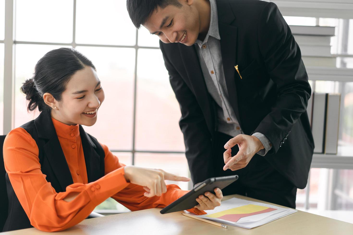 heureux jeunes hommes d'affaires asiatiques adultes travaillent et parlent d'idée ensemble au bureau le jour. photo