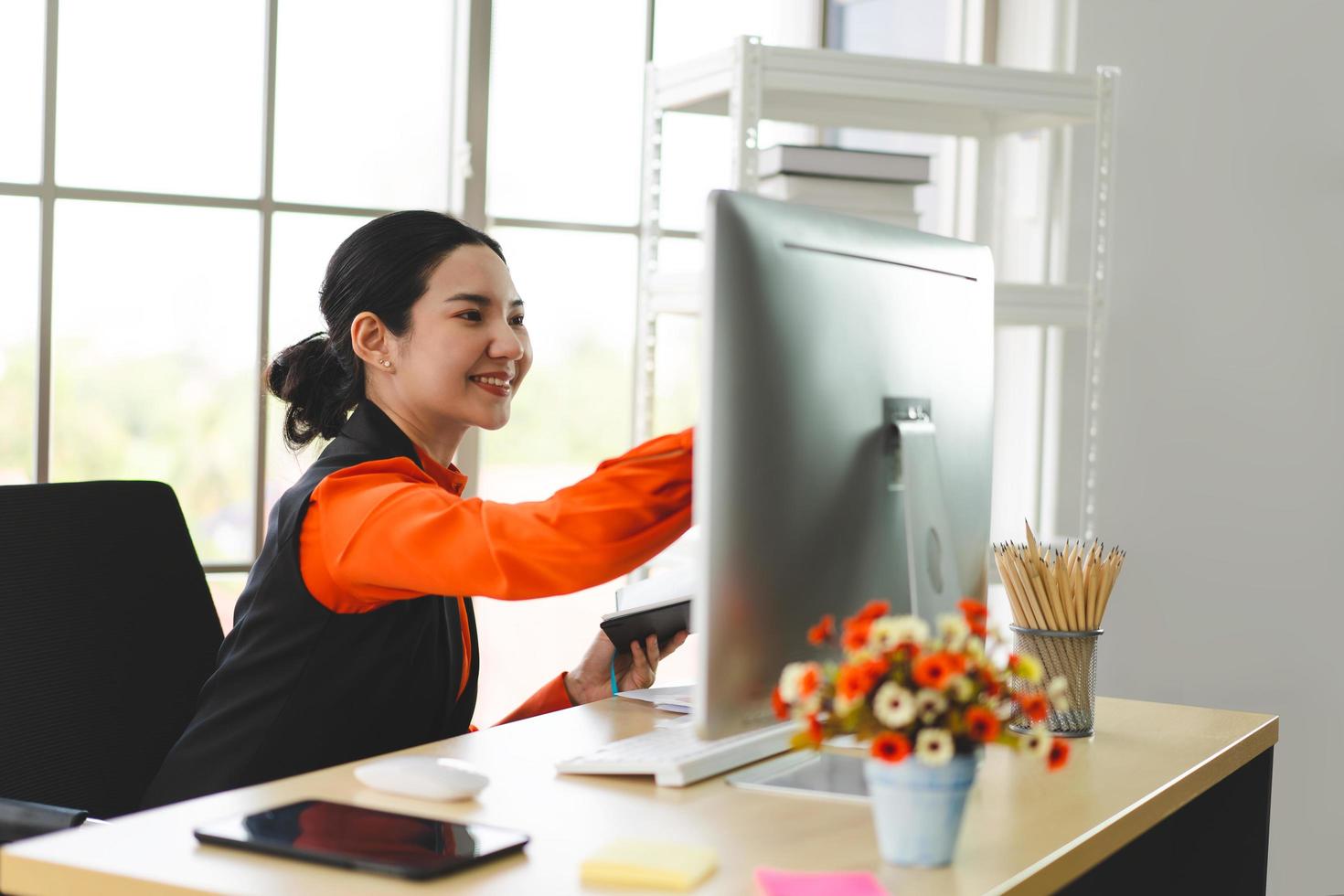 jeune femme d'affaires asiatique adulte travaillant avec un ordinateur au bureau de travail le jour. photo