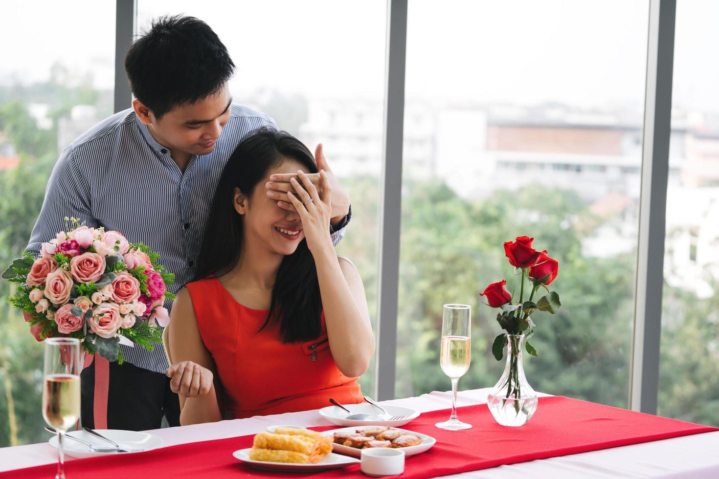 amoureux avec bouquet de fleurs surprise à table. photo