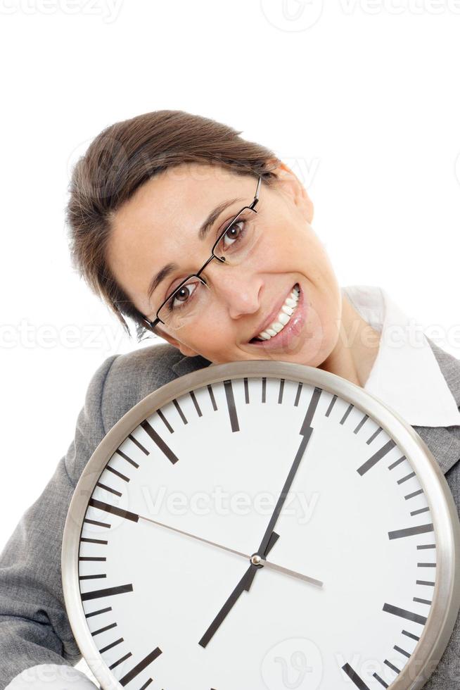 jeune femme d'affaires souriant tenant une horloge sur fond blanc. photo