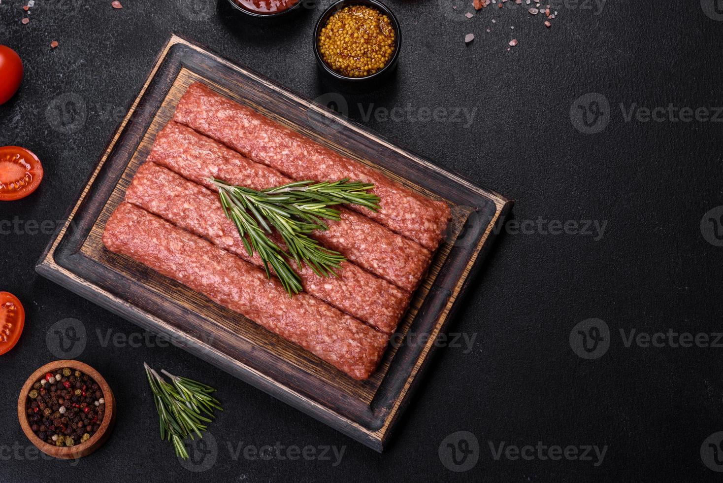 hachis cru frais pour kebab grillé avec épices et herbes sur fond de béton foncé photo