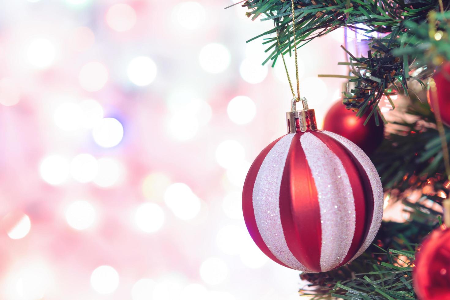 décoration de Noël. boules rouges accrochées aux branches de pin guirlande d'arbre de noël et ornements sur fond abstrait bokeh with copy space photo