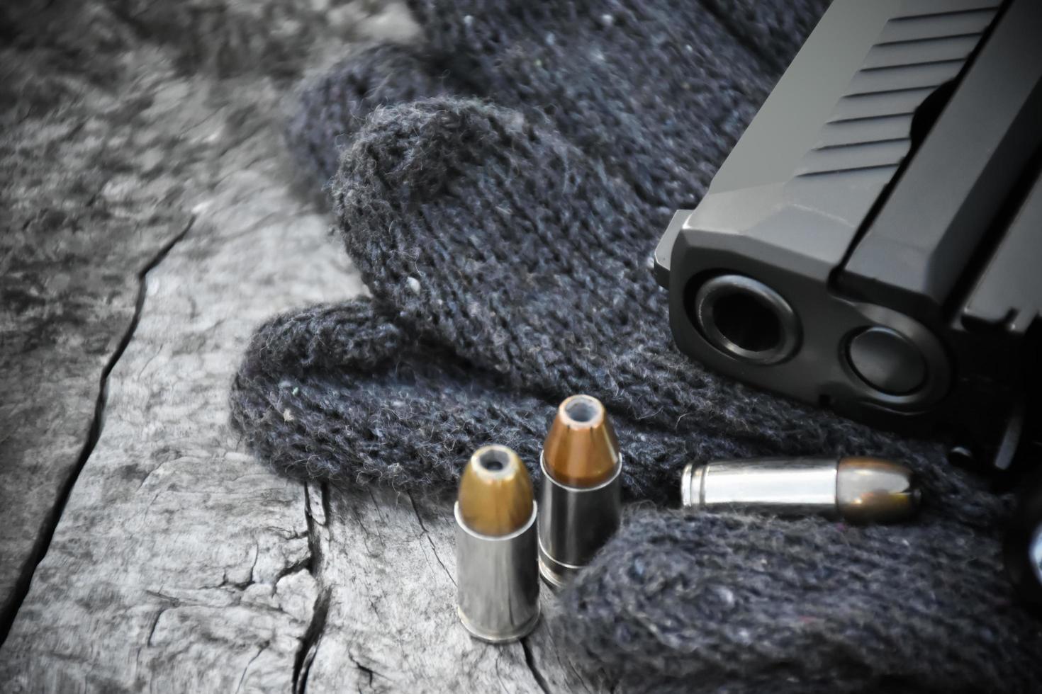 pistolet noir automatique de 9 mm, munitions et cartouches sur table en bois. mise au point sélective spécifique au pistolet. photo