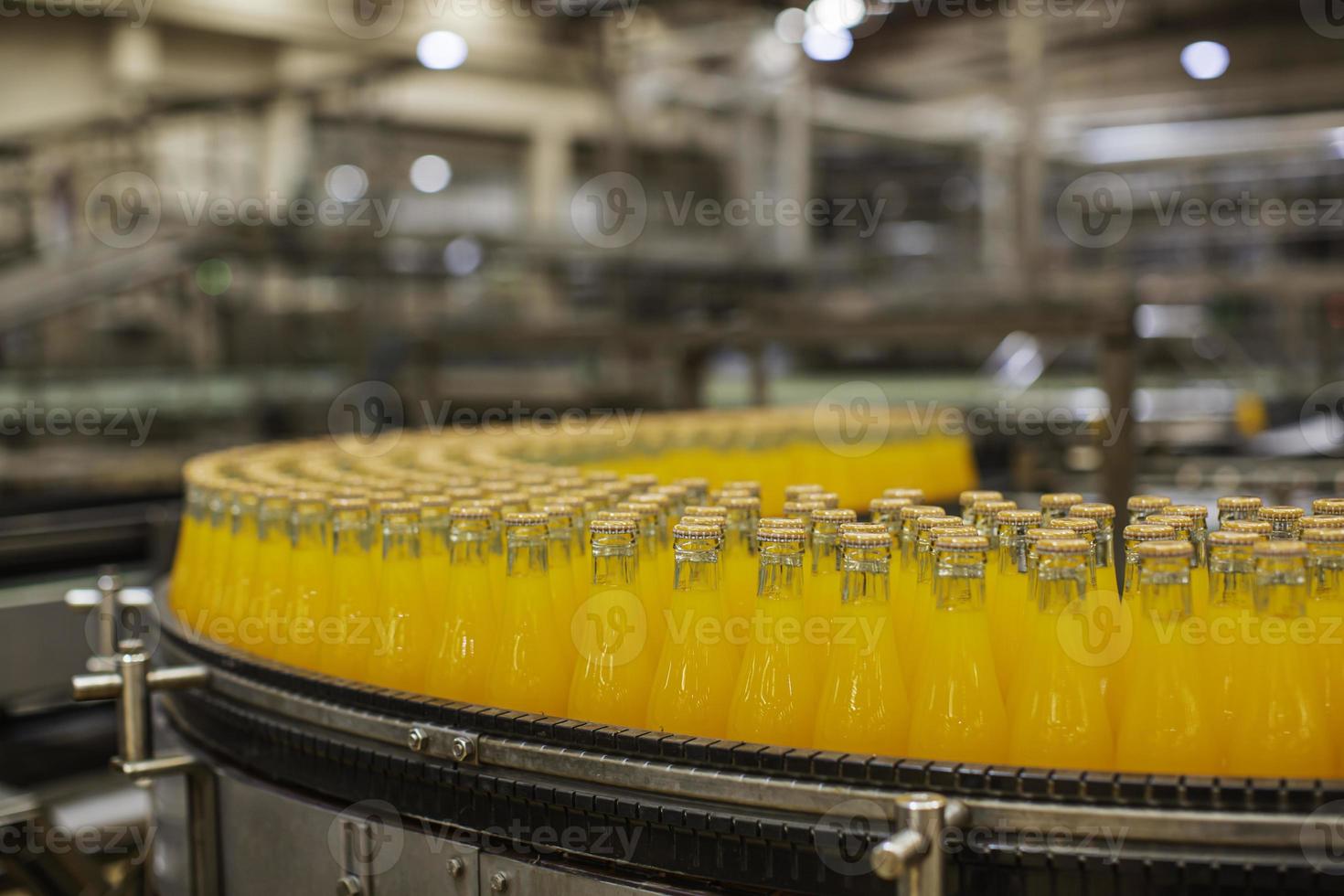 intérieur de l'usine de boissons. convoyeur qui coule avec des bouteilles de jus photo