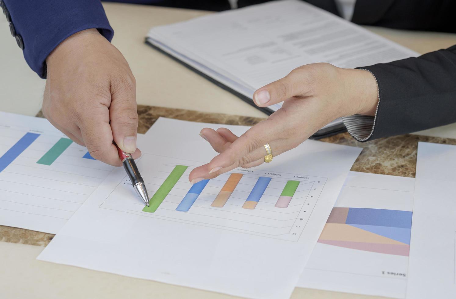 mise au point sélective entre les mains d'une femme d'affaires et d'un superviseur pointant un graphique lors de l'analyse du plan de vente de l'entreprise dans la salle de bureau photo