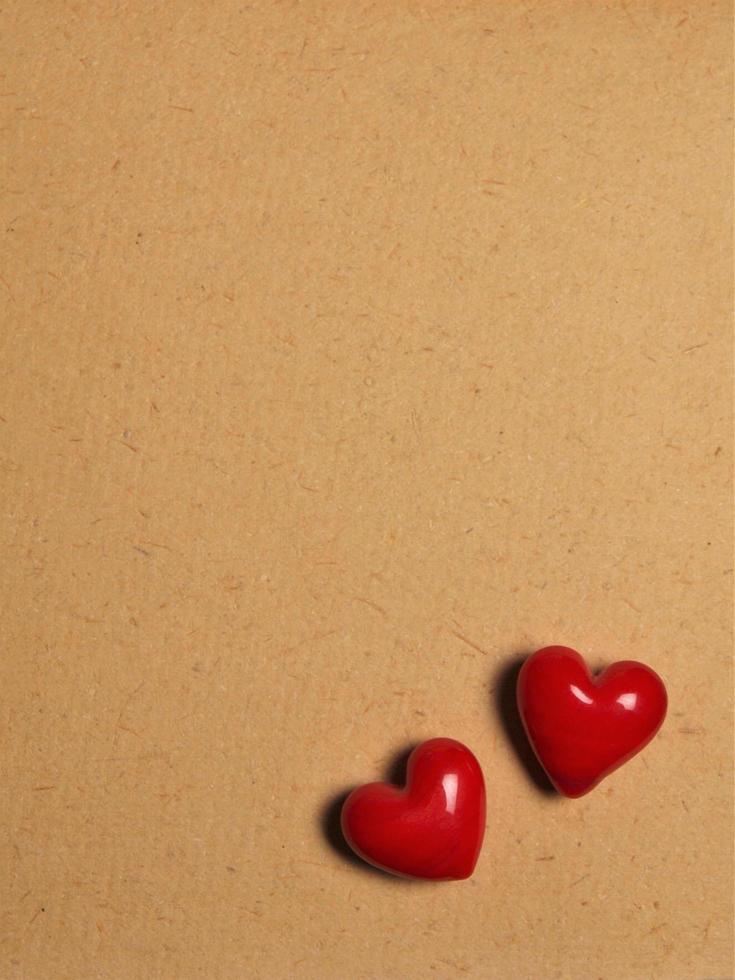 deux coeurs en céramique rouge sur fond de papier de lettre d'amour photo
