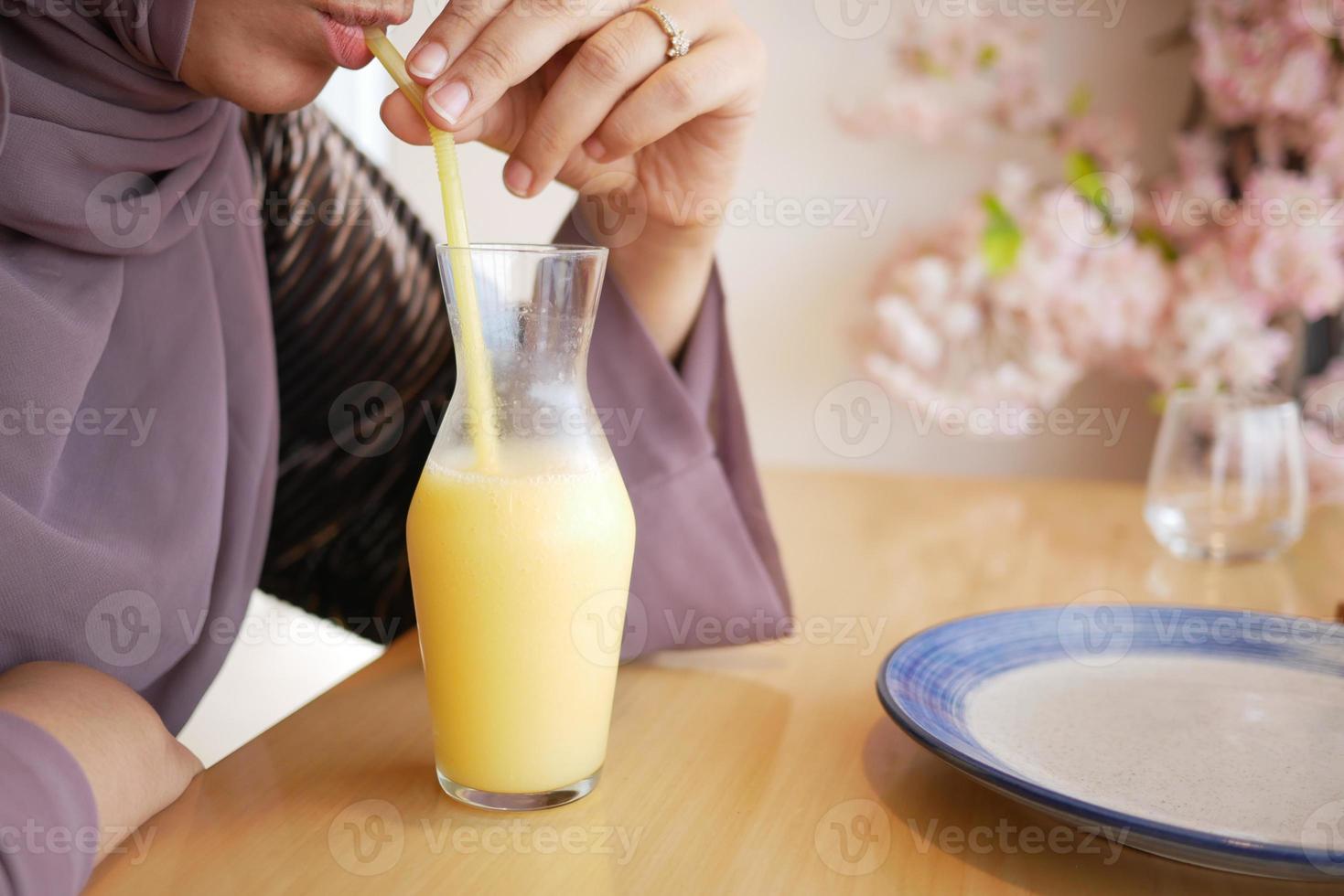 femmes buvant du jus d'ananas dans une bouteille sur la table photo