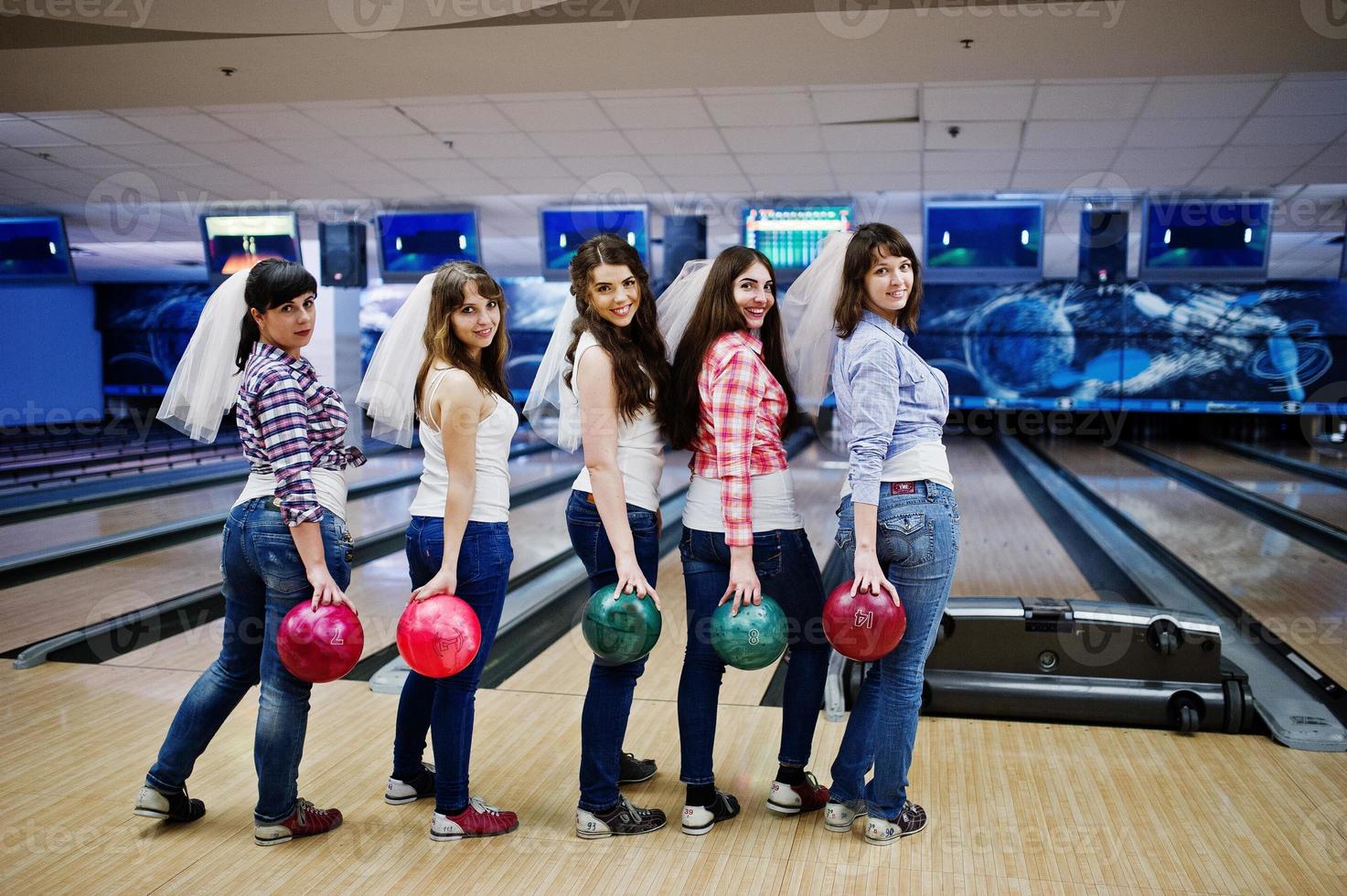 groupe de six filles avec des boules de bowling à la fête de poule au club de bowling. photo