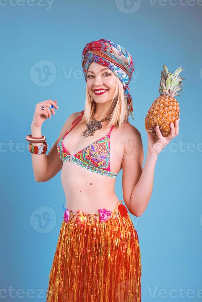 belle femme blonde souriante joyeuse en bikini dans un style tropical sur fond bleu. voyage et culture photo