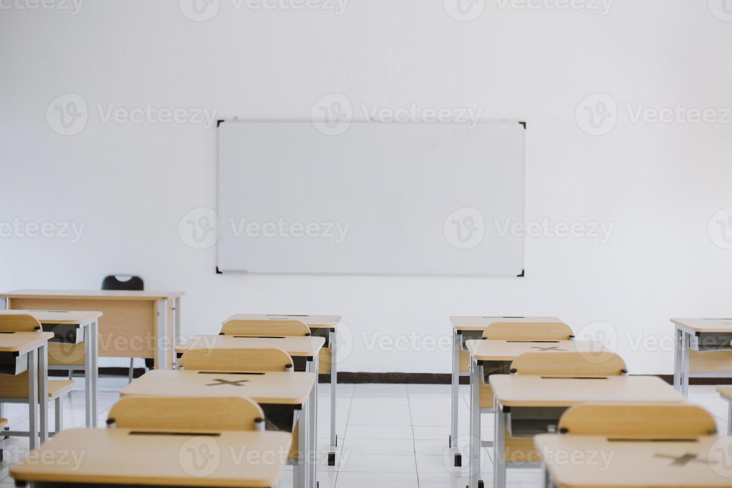 salle de classe moderne vide avec chaises, bureaux et tableau blanc photo