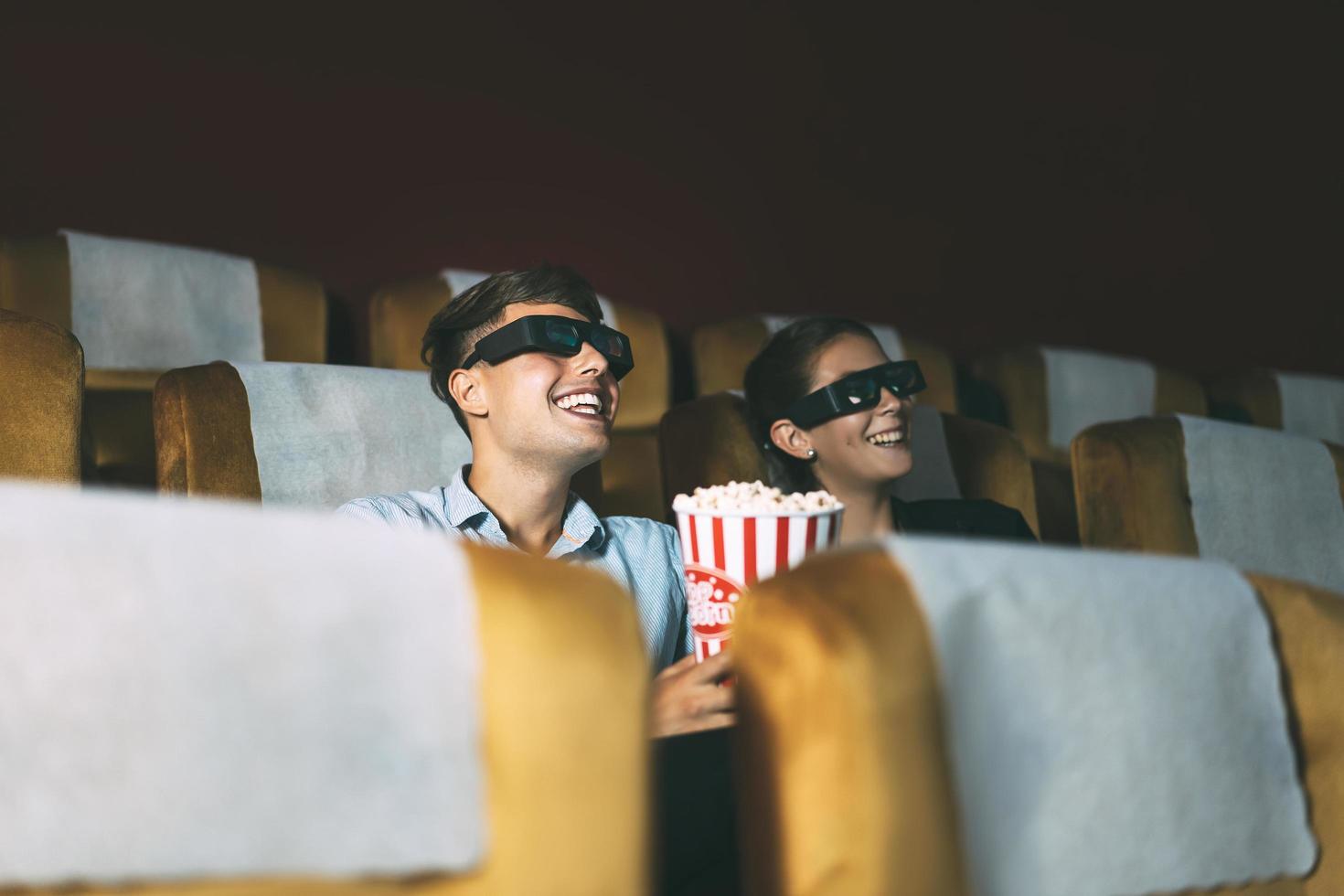 jeunes adultes caucasiens regardant un film au théâtre. photo