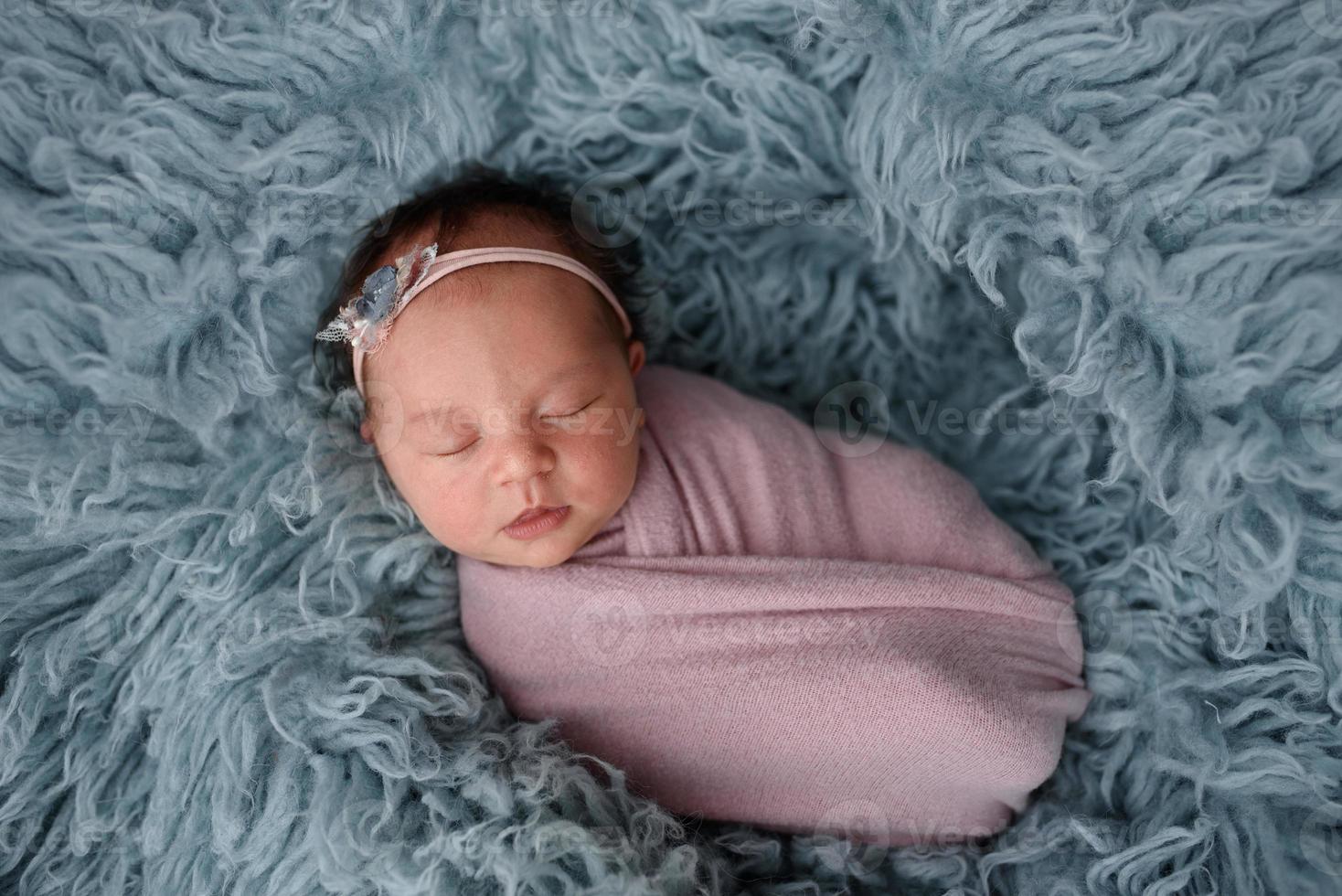portrait d'un nouveau-né endormi en fourrure bleue photo