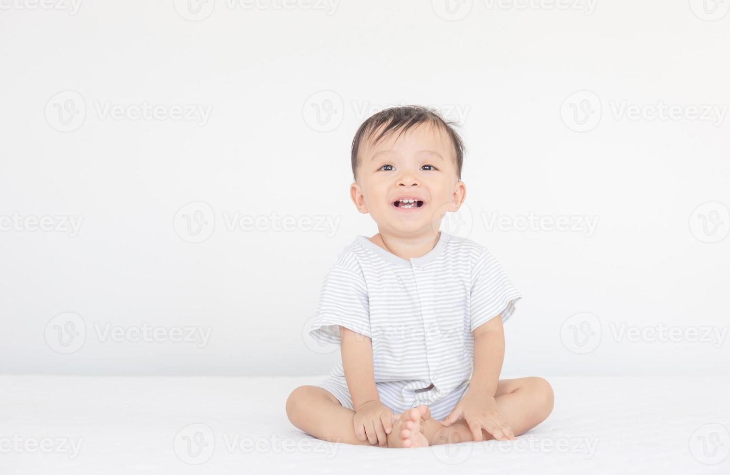 bonheur et sourire bébé garçon riant sur le lit, enfants jouant concept photo