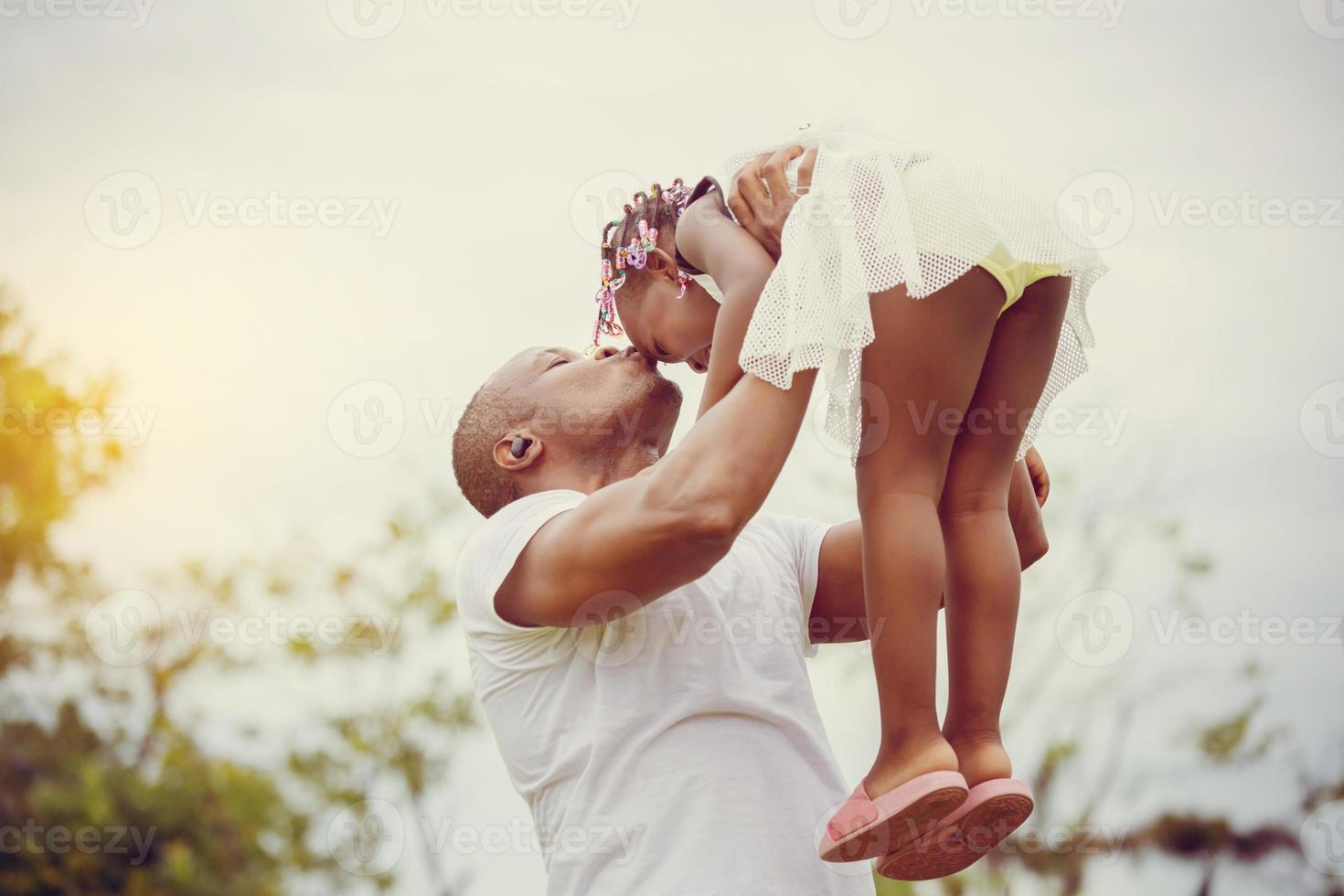 père heureux jouant avec sa fille, joyeuse fille afro-américaine jouant avec son père photo