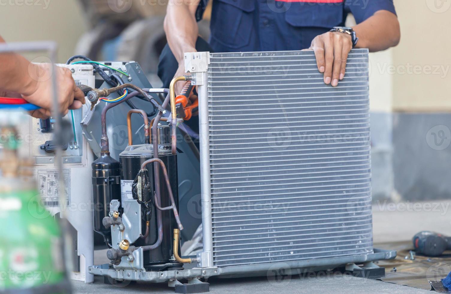 gros plan de l'équipe de réparation de la climatisation utilise des gaz combustibles et de l'oxygène pour souder ou couper des métaux, des procédés de soudage oxy-combustible et de coupe oxy-combustible, réparateur au sol fixant le système de climatisation photo