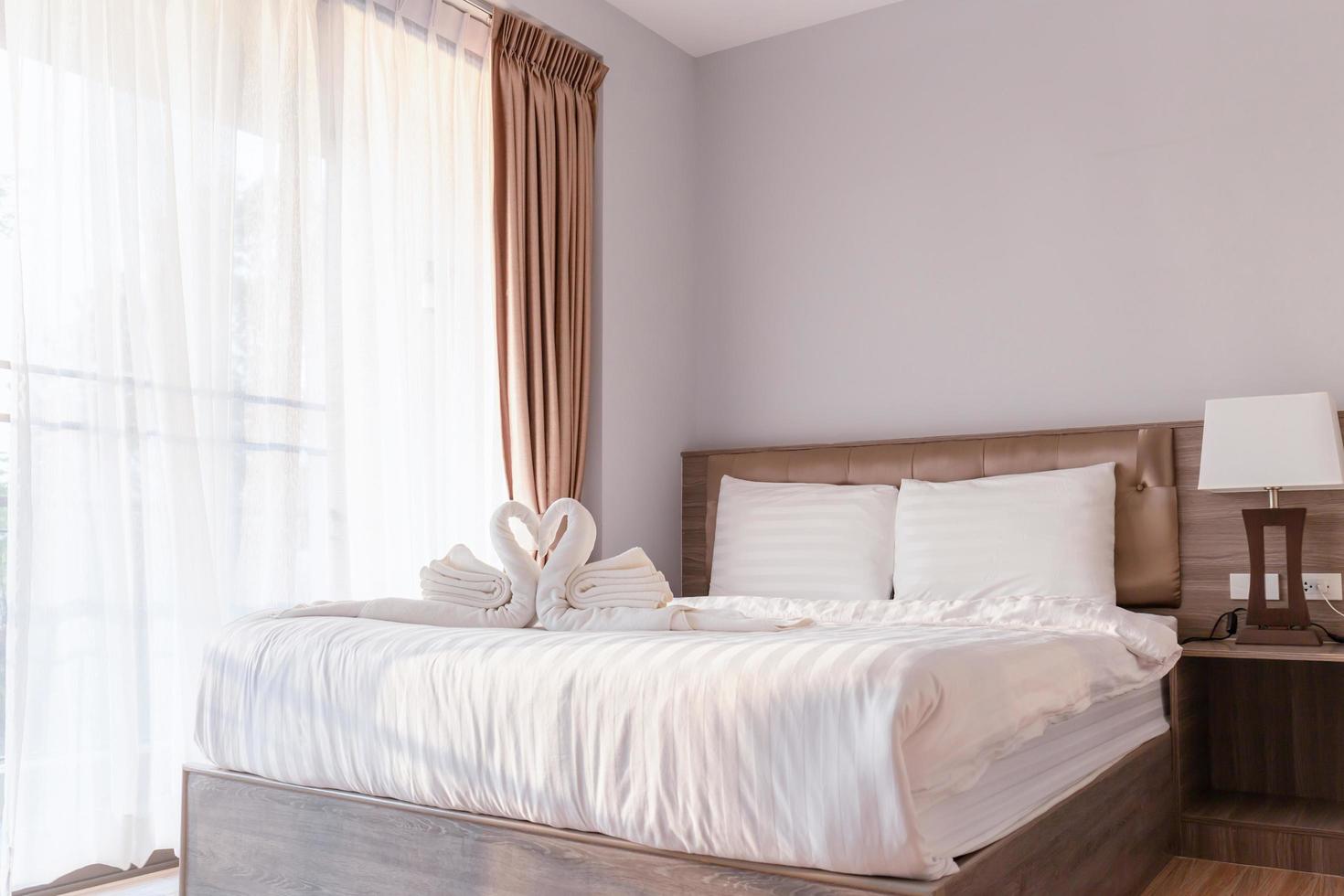 chambre à coucher avec serviette pliée en forme de cygne sur drap de lit photo