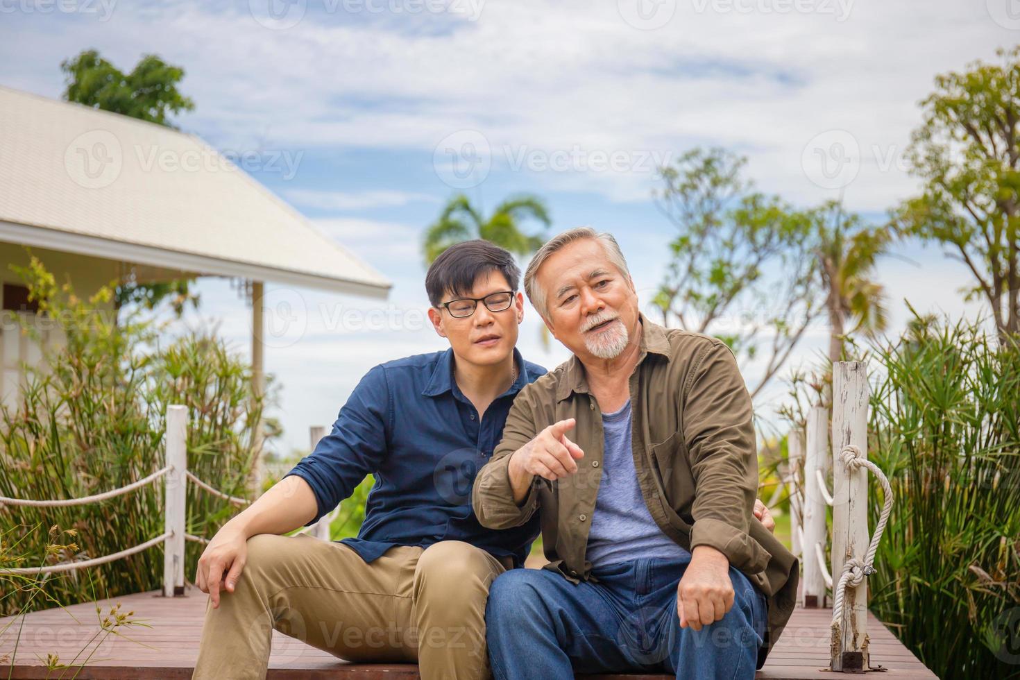 père asiatique âgé et fils d'âge moyen assis se détendre ensemble à l'extérieur, concepts de famille asiatique de bonheur photo