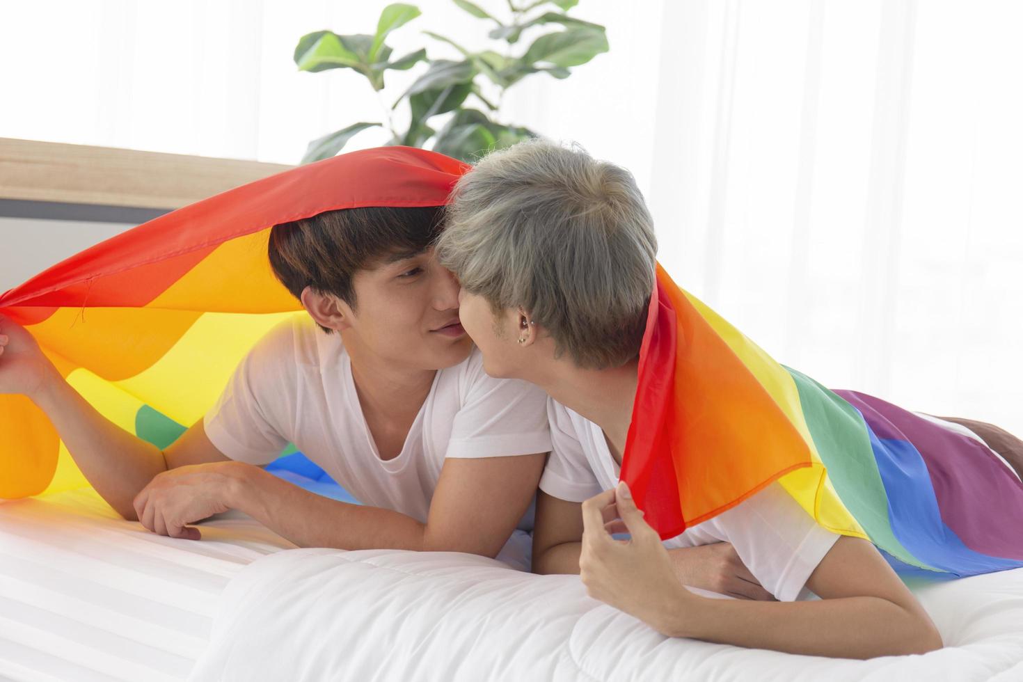 les couples masculins et asiatiques portent sur la tête un drapeau multicolore portant des signes lgbt, exprimant ouvertement les hommes homosexuels acceptant les concepts lgbt. photo