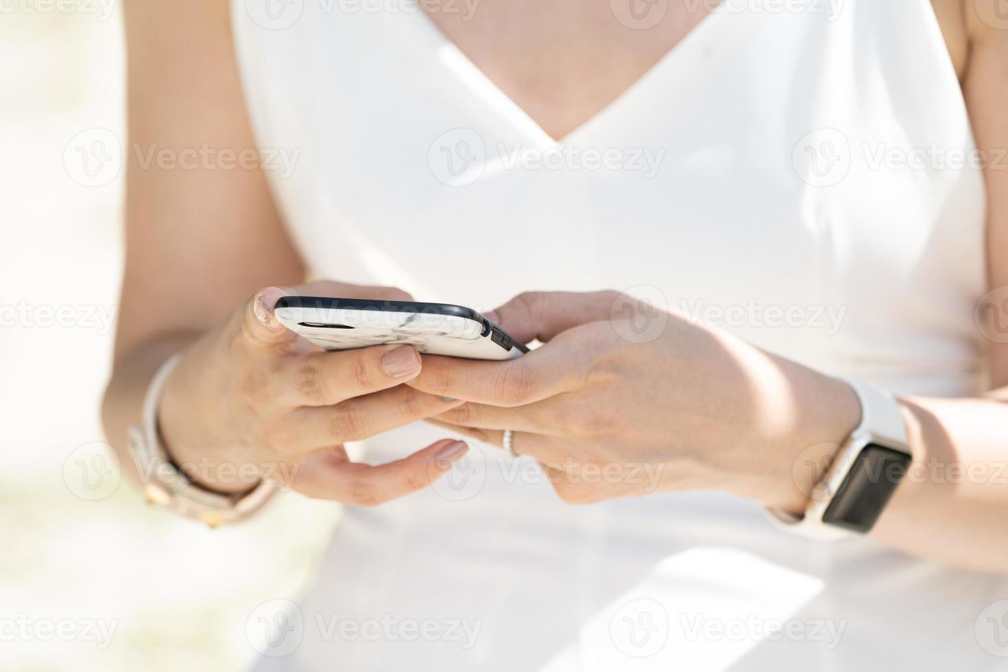 gros plan une mariée tape un message dans le téléphone mobile. photo