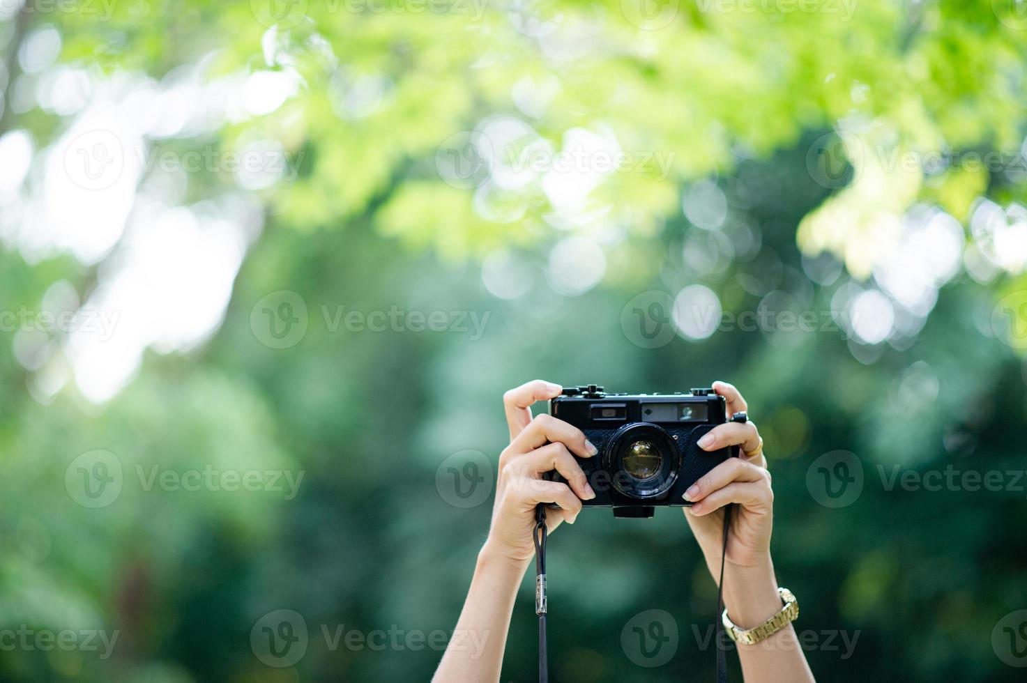 photographe et amateur d'appareil photo appareil photo noir et fond vert naturel